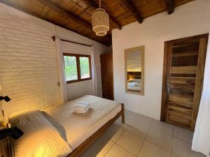 a bedroom with a bed and a window at Las Golondrinas Ayampe in Ayampe