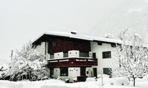 a building covered in snow in front of a mountain at Haus Galgenul by A-Appartments in Galgenul