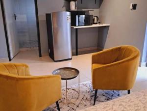 RandfonteinにあるGuesthouse in Randfonteinのリビングルーム(椅子2脚、冷蔵庫付) +3枚の写真