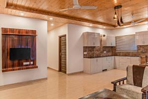a living room with a kitchen and a tv at Holidays Homes Kasauli by Exotic Stays in Kasauli