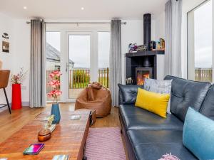 a living room with a couch and a fireplace at Go Ye Cottage in Leurbost
