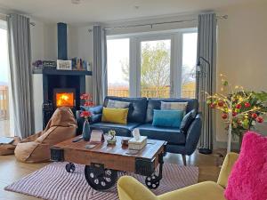a living room with a blue couch and a table at Go Ye Cottage in Leurbost