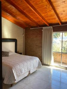 a bedroom with a bed and a large window at Ohana Apartments (solo familias) in Villa Carlos Paz +21 photos