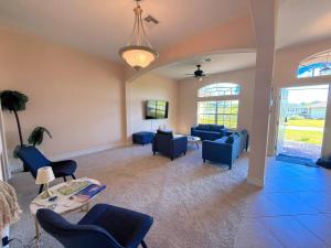 ein Wohnzimmer mit blauen Sofas und einem Tisch in der Unterkunft Waterfront VILLA with heated Pool&Spa, sunset view, Family&Pets Friendly in Cape Coral