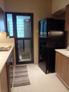 a kitchen with a black refrigerator and a window at Gems Havelock Apartment in Colombo +13 photos