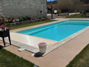 una piscina con una bebida en una jarra al lado en L’ÉCURIE, en Gigny 15 fotos más