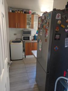 a kitchen with a refrigerator with magnets on it at Hospedaje en departamento compartido in Valparaíso