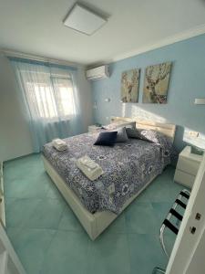a bedroom with a large bed with blue walls at Casa Maria Grazia Camera vista mare in Anacapri