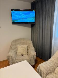 a living room with a couch and a flat screen tv at Apartament Lux 3 camere in Roman