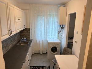 a kitchen with a washing machine and a window at Apartament Lux 3 camere in Roman +14 photos