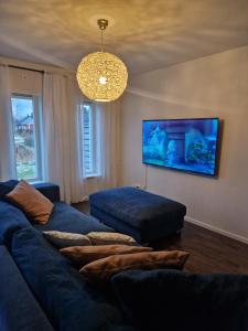 a living room with a blue couch and a tv at ArcticStay Economy in Pajala