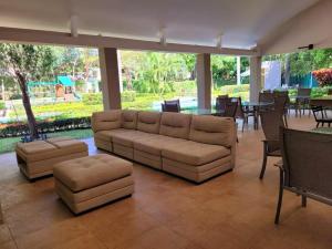 ein Wohnzimmer mit einer Couch sowie Tischen und Stühlen in der Unterkunft Walk to Downtown Santa Ana, Near Airport, Lush Gardens, Pool, King Bed, Security in Santa Ana