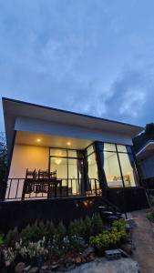 ein Haus mit einem großen Fenster und einem Balkon in der Unterkunft อินทนนท์ บ้านพักเล่าจู Inthanon Laoju House in Ban Na Yang