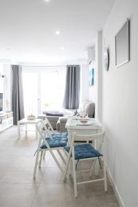 ein weißes Wohnzimmer mit Tisch und Stühlen in der Unterkunft SEA IRUHoUSE in Málaga