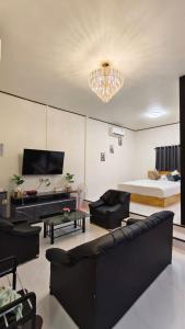 ein Wohnzimmer mit einem Sofa, einem Bett und einem Kronleuchter in der Unterkunft อินทนนท์ บ้านพักเล่าจู Inthanon Laoju House in Ban Na Yang