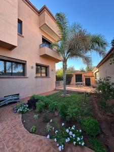 a house with a palm tree and a courtyard at Villa Amroth in Marrakech