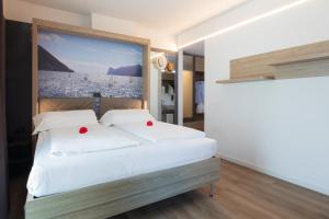 a bedroom with a bed with a large painting on the wall at Ambassador Suite Hotel in Riva del Garda +76 photos