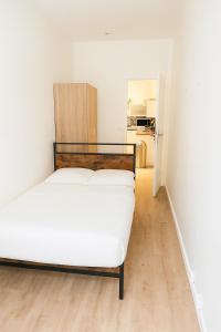 a bedroom with a white bed in a room at Le 9 Privé Chambres Chic à Puteaux près Paris, kitchen et 2 SDB ideal couples et Professionnels en déplacement in Puteaux