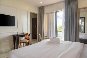 a hotel room with a bed and a desk and a television at Waterfront Villas And Wellness SPA in Warri +83 photos