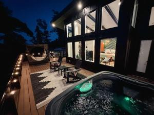 ein Haus mit einem Whirlpool auf einer Terrasse in der Nacht in der Unterkunft Private Lux Getaway Hot Tub Double Shower Cabana in Campton