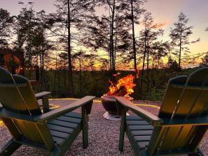 zwei Stühle vor einer Feuerstelle in der Unterkunft Private Lux Getaway Hot Tub Double Shower Cabana in Campton