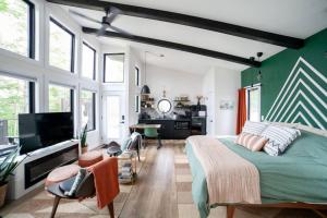 ein Schlafzimmer mit einem Bett und einem Flachbildfernseher in der Unterkunft Private Lux Getaway Hot Tub Double Shower Cabana in Campton