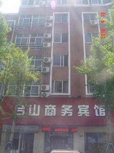 un edificio alto con escritura asiática en el costado en Taizhou Taishan Business Hotel, en Taizhou