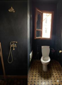 ein Badezimmer mit Toilette und Fenster in der Unterkunft Villa d'Exception à Ourika Nichée au Cœur des Montagnes in Aghbalou