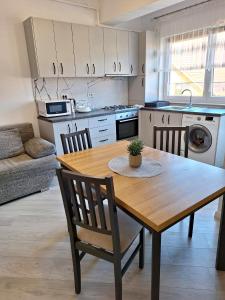 eine Küche mit einem Holztisch und Stühlen in der Unterkunft Central 3 Rooms Retreat - Rădăuți in Rădăuţi