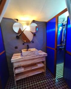 a bathroom with a sink and a mirror on the wall at Desert Pearl Camp in Merzouga