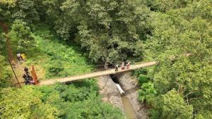 a group of people on a bridge in a forest at COZY 2BR Pinewood Apt Jatinagor in Cilimus 2