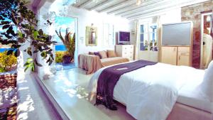 a bedroom with a bed and a couch in it at Manu Mykonos Next to the Beach Quality Brand Villa & Bungalows in Mýkonos City