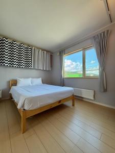 een slaapkamer met een bed en een groot raam bij The Lobs 2, Rusutsu, Yotei view, 8 mins to Rusutsu in Kimobetsu