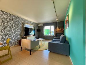 a living room with a blue couch and a tv at The Lobs 2, Rusutsu, Yotei view, 8 mins to Rusutsu in Kimobetsu