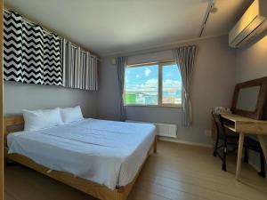 een slaapkamer met een bed, een bureau en een raam bij The Lobs 2, Rusutsu, Yotei view, 8 mins to Rusutsu in Kimobetsu