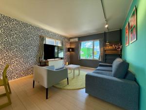 een woonkamer met een blauwe bank en een tv bij The Lobs 2, Rusutsu, Yotei view, 8 mins to Rusutsu in Kimobetsu