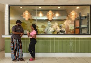 a man and a woman standing at a counter at Waterfront Villas And Wellness SPA in Warri