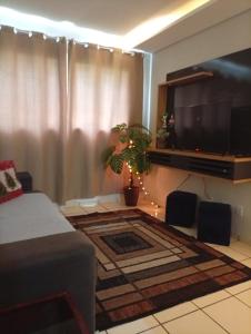 ein Wohnzimmer mit Flachbildfernseher und Couch in der Unterkunft Apartamento Rainha Turquesa in Dourados + 18 Fotos