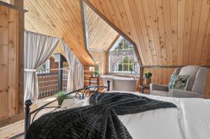 une chambre avec un lit dans une pièce aux murs en bois dans l'établissement Domaine Rivière Sacacomie - Chalet Le Cardinal, à Saint-Alexis-des-Monts 17 autres photos