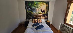 a bedroom with a bed with a painting on the wall at El Mirador de Tanes in Tanes