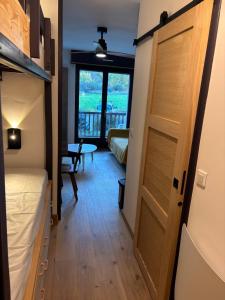 a room with a door and a bedroom with a table at Studio à Vallouise-Pelvoux - Puy Saint Vincent, nature, rando et ski in Vallouise