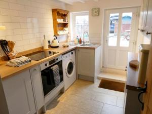 a kitchen with a sink and a washing machine at Jenny's Cottage 27553 in Mundesley