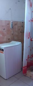 biała lodówka w pokoju z zasłoną prysznicową w obiekcie Maison exurville w mieście Le Robert
