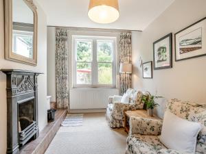 a living room with a fireplace and a chair at The Carriage House in Llanwenarth