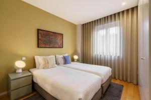 a bedroom with a large white bed and a window at Bracara Home By Minhos Guest in Braga