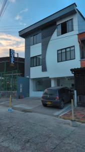 a car parked in a parking lot in front of a building at Hotel Casa Camoa in Villavicencio