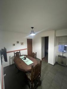 Un comedor con mesa y sillas de madera. en Depto 39, en La Plata