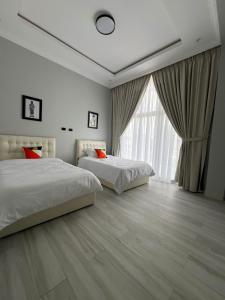 a bedroom with two beds and a large window at villa Rosetta in Lege Tʼafo