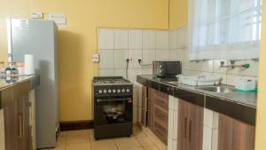 a kitchen with a stove and a sink at Zen Escape Nanyuki in Nanyuki
