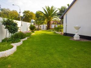 RandfonteinにあるGuesthouse in Randfonteinの緑草の庭と白い建物